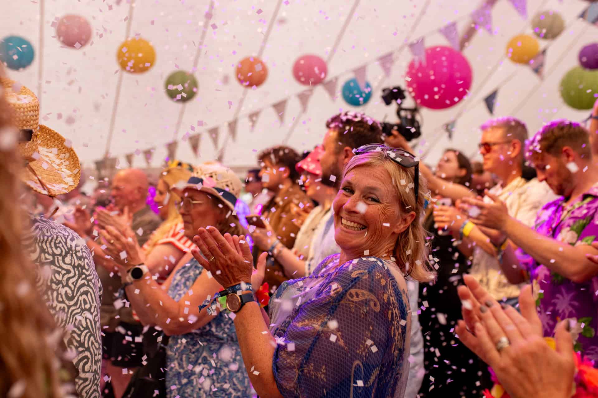 Festival goers in the Kashmir tent with confetti falling from above
