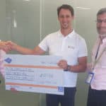 Three men posing for the camera with a giant cheque