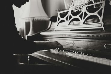 black and white photo of man playing the piano