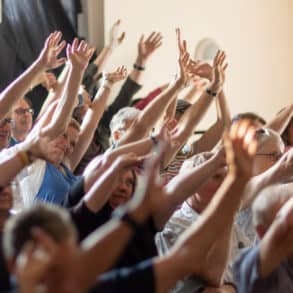 fringe audience with hands in the air