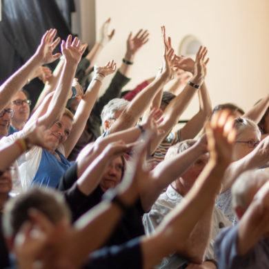 fringe audience with hands in the air