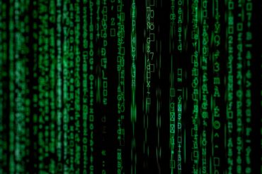 matrix movie still of green computer text on black background