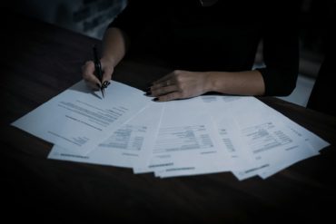 person looking through paperwork on a desk