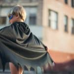 young boy in superhero batman cape and mask