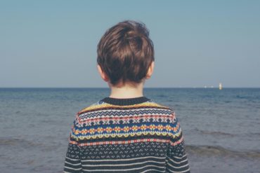 young boy looking out to sea