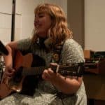 Amy Jolliffe playing guitar in the studio