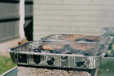 Disposable BBQ on breeze blocks in someone's garden