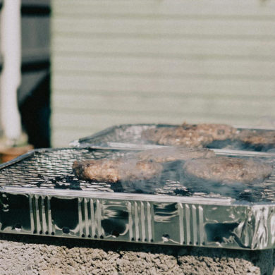Disposable BBQ on breeze blocks in someone's garden