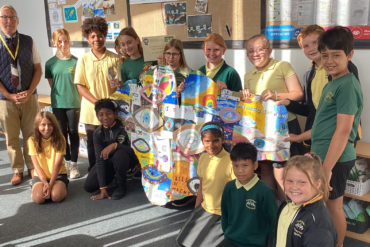 Greenmount primary school pupils holding their artworks, with Graham Biss