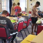 Parents and children taking part in creative workshop at the library