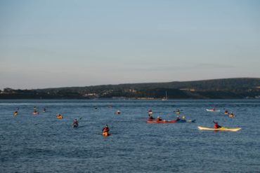 Swimmers and kayakers crossing the Solent by Michael Dangerfield