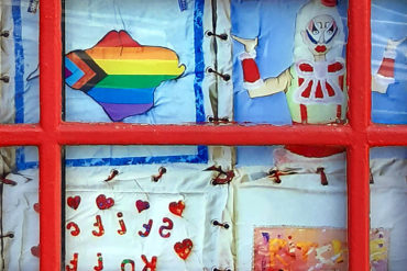 Close up of the AIDS memorial quilt in the window of the phone box