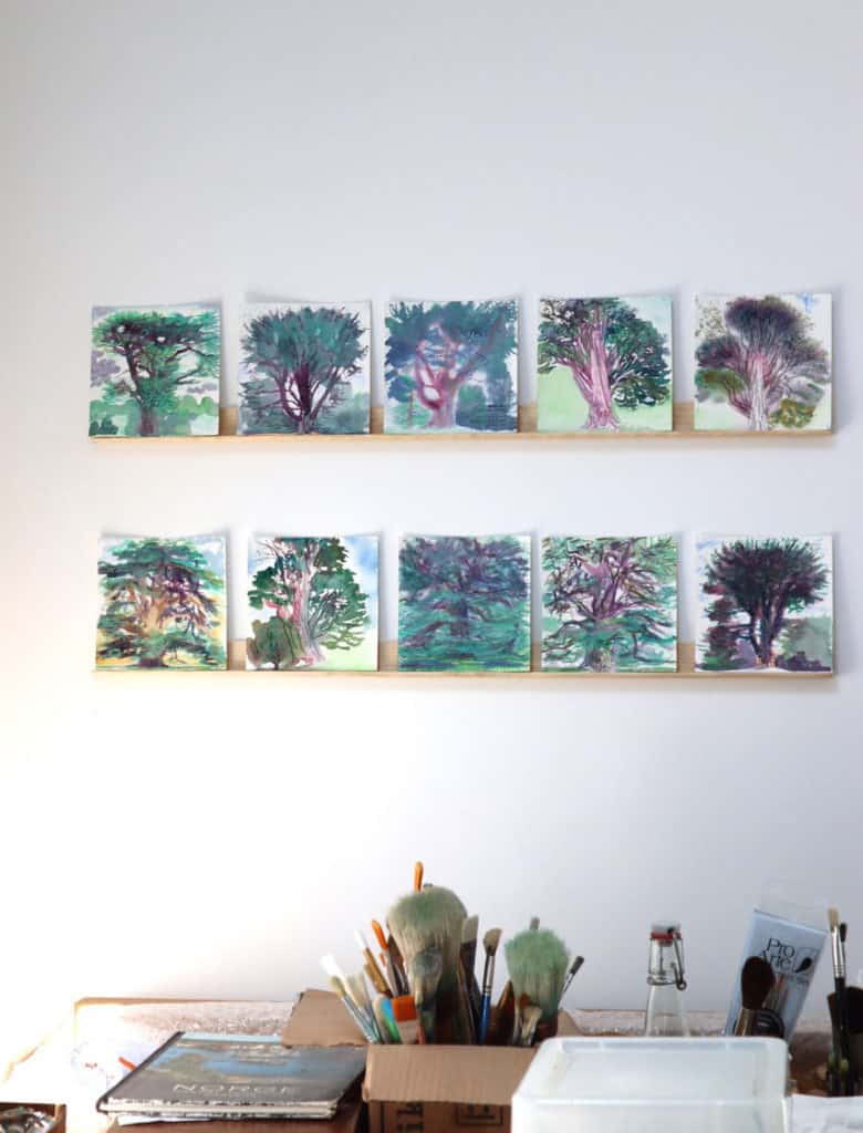 Paintings on the wall in Sadie's studio, with her desk area in the foreground