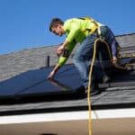 Two men on a domestic roof, fitting solar panels