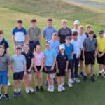 Group of children on golf course with banner about fighting mitochondrial diseases