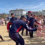 children saluting RAF Falcons on the beach at Armed Forces Day