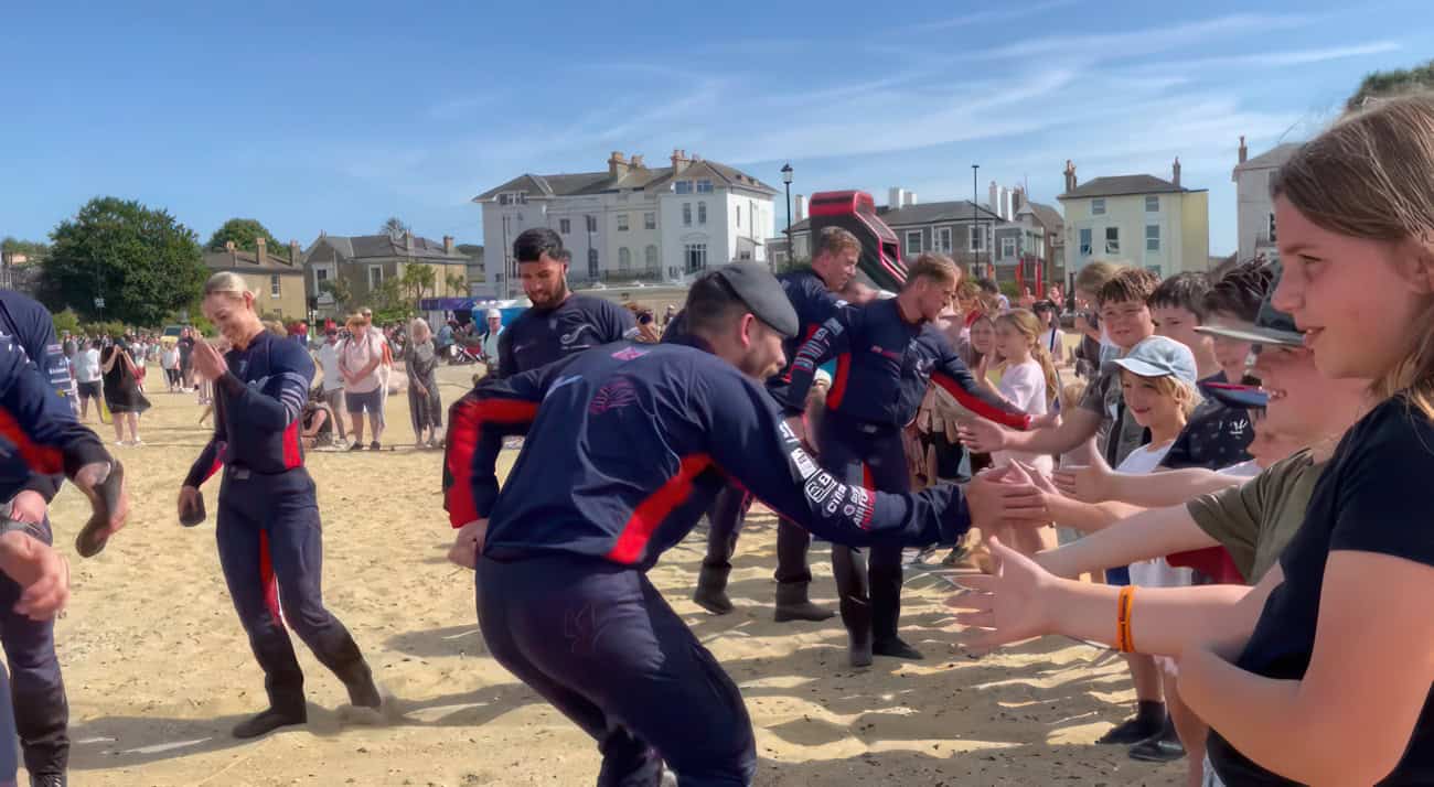 children saluting RAF Falcons on the beach at Armed Forces Day