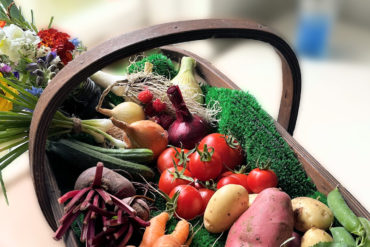 A basket of fresh vegetables and flowers