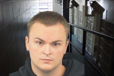 Mugshot of Georgie Goodier with jail corridor in background