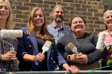 Volunteers with paint brushes outside the Church Close Community Centre
