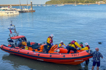Cowes RNLI crew and paramedics transfer the casualty to the lifeboat