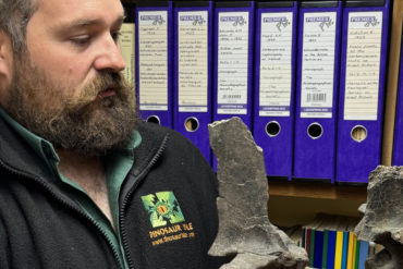 Dr Simon Penn holding 2 of the animal's vertebrae