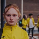 Girl in sportswear looking at the camera, with an unhappy look on her face