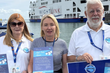 Rita Smith, social organiser, IWPCSG, Sara Howden, Roger Denness, IWPCSG chairman standing by the Wightlink ferry holding posters for those with prostate issues