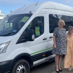 Sally and Michelle Newton standing by the new Daisy Bus minibus service with Red Funnel ferry in the background