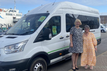 Sally and Michelle Newton standing by the new Daisy Bus minibus service with Red Funnel ferry in the background
