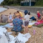 People on the beach getting ready to learn and collect plastic