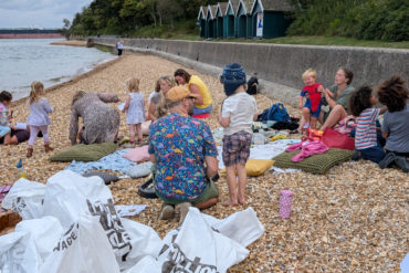 People on the beach getting ready to learn and collect plastic