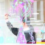 Teenage female drawing pictures on Glass window