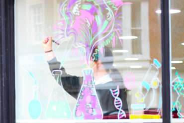 Teenage female drawing pictures on Glass window