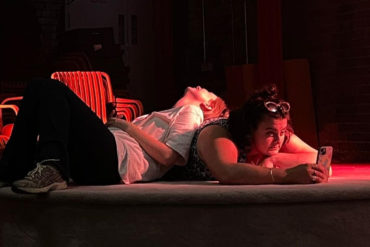 Two stroke rehearsals with two actors on stage with red lighting