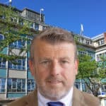 Mugshot of David Maclean overlaid on photo of county hall