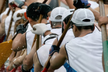 Photo of men taking part in dragon boat racing
