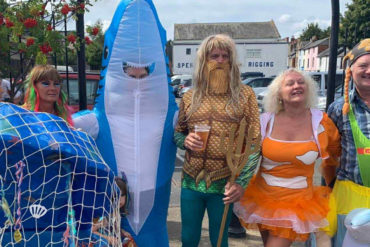 People dressed as characters relating to the sea, a shark, a mermaid, fish and Poseidon
