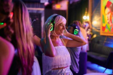 young people dancing whilst wearing silent disco headphones