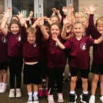 Bembridge primary school pupils with their hands in the air