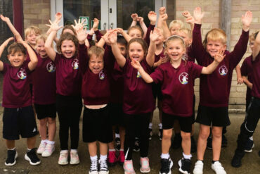 Bembridge primary school pupils with their hands in the air