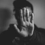 Black and white photo of a woman holding her hand out palm forwards