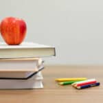 Books and apple and ABC blocks on a school desk