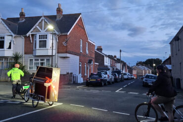 Keert's rider with the piano behind and Mr Lynch on bicycle behind