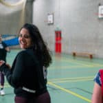 Women playing netball whilst smiling