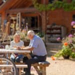 Older couple sitting in the garden of the Garlic Farm with bicycles next to their table