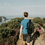 a man walking by headon warren on the Isle of Wight with countryside in the background