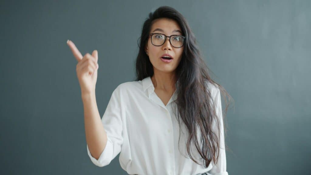 asian woman in white blouse having a lightbulb moment