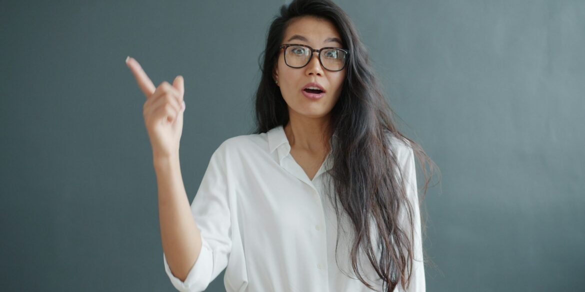asian woman in white blouse having a lightbulb moment