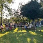 People sitting in the garden on a summer day as the presentations take place